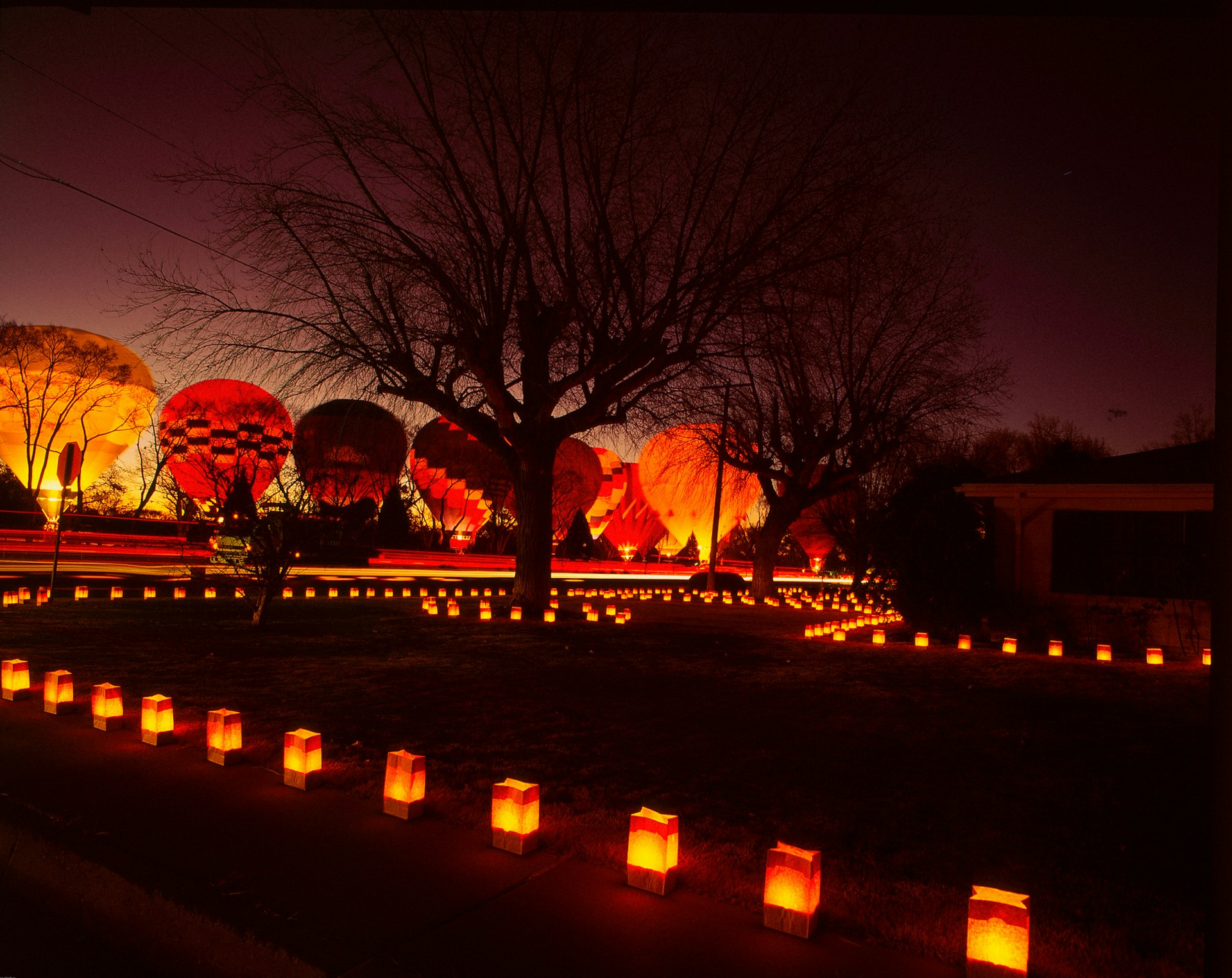 Hot-air balloons and luminarias glowing at night in Old Town Albuquerque