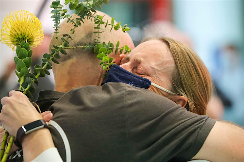 Les gens se saluent dans le hall des arrivées après avoir atterri à l'aéroport de Sydney 