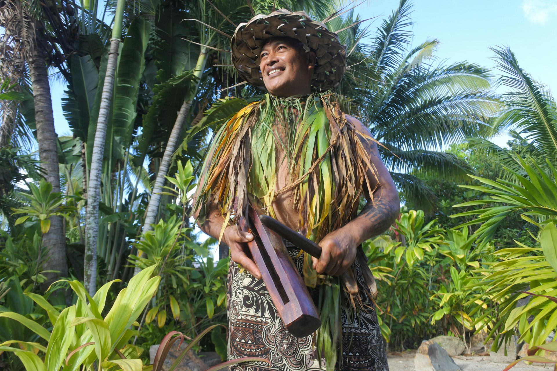 A Cook Islands musician beats out a rhythm on a traditional pate (slit drum)