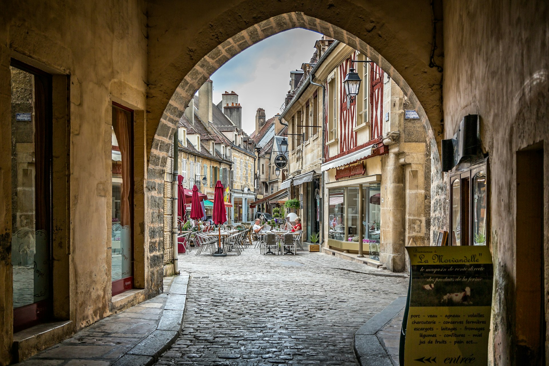 A view of the old town in Semur-en-Auxois through an archway and along cobbled streets