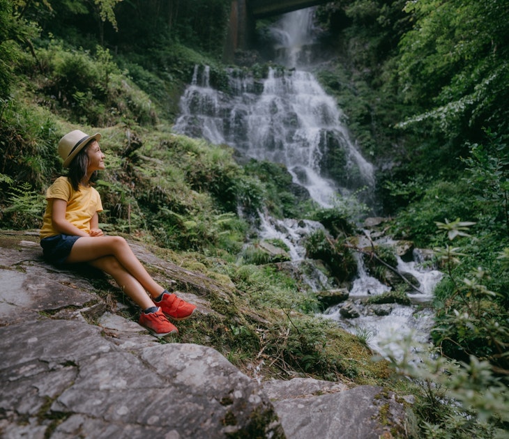 Young girl in forest with waterfall, Kochi, Shikoku, Japan