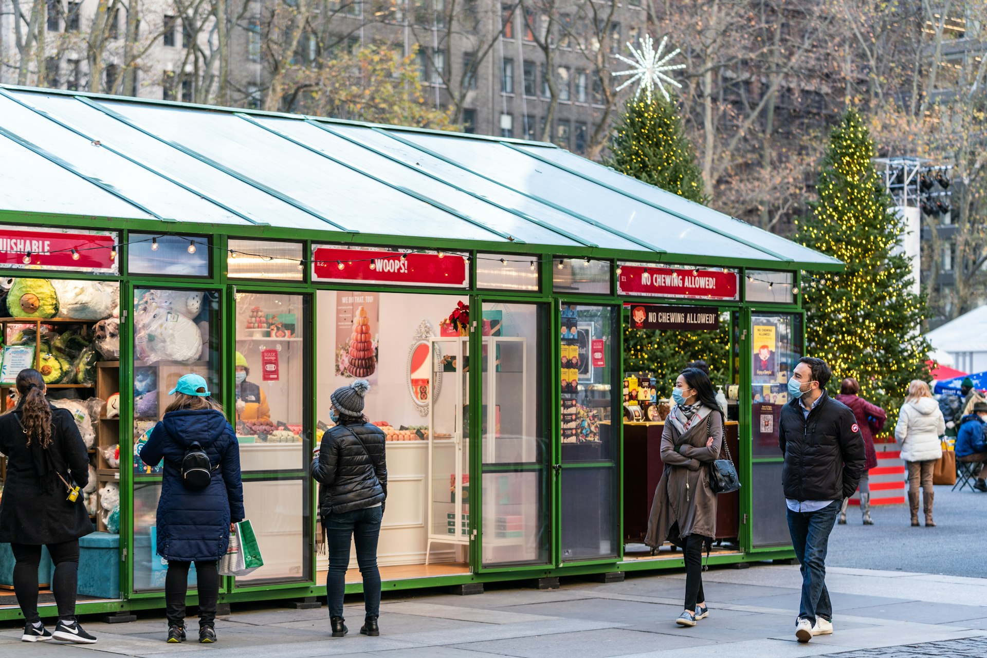 A pair of young people wearing masks and walking through Bryant Park's holiday market