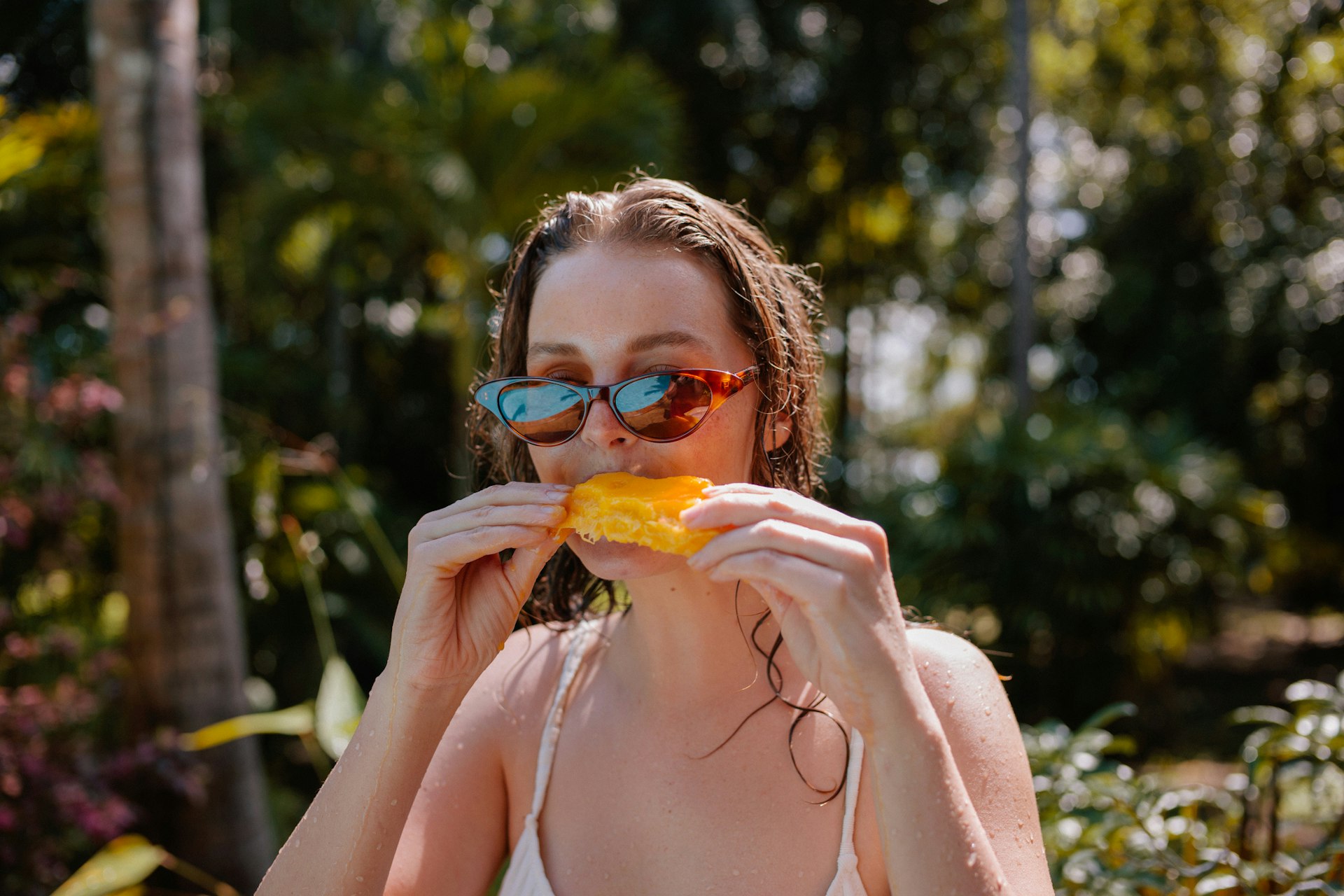 Young Woman Eating Mango On Vacation
