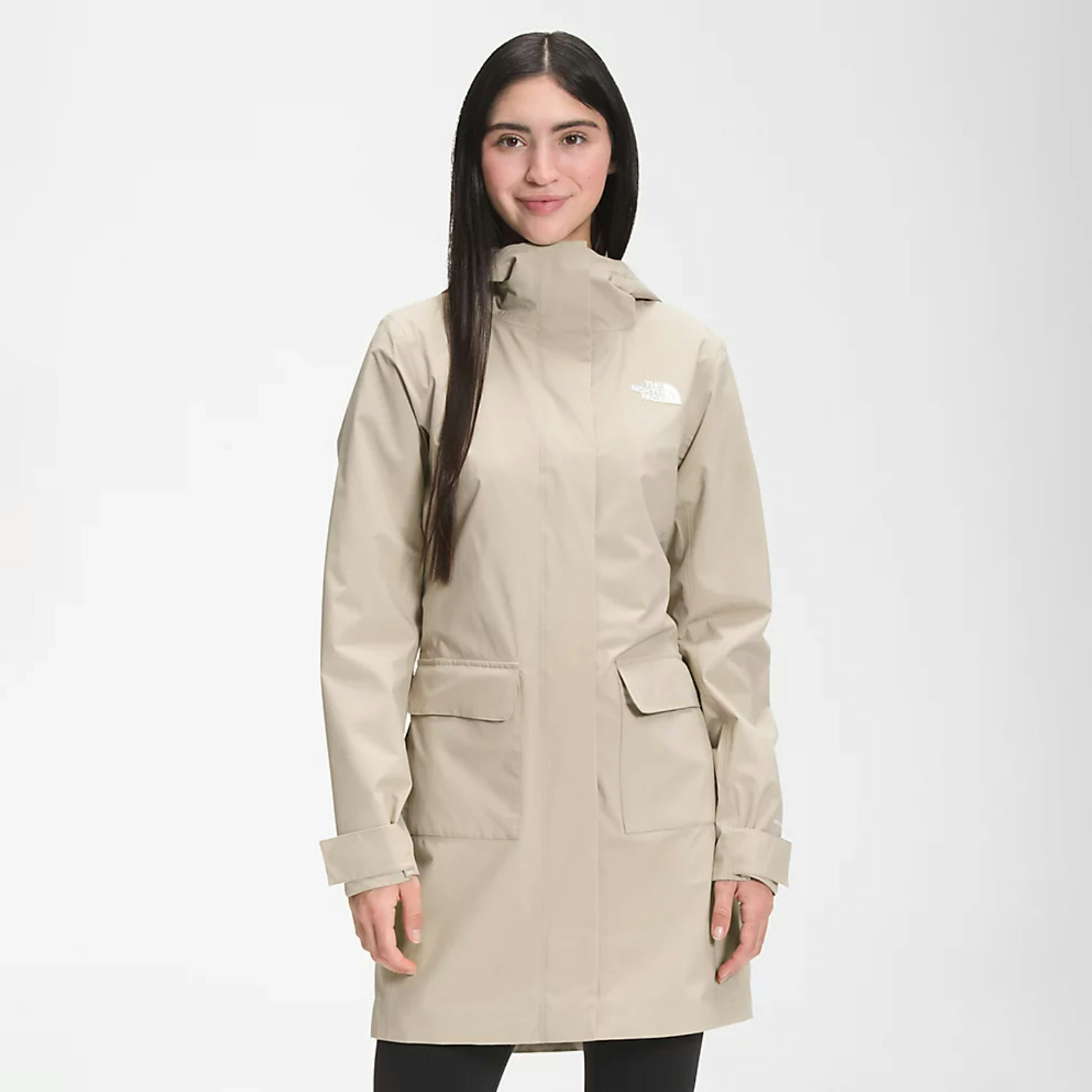 A brunette woman wearing NorthFace's cream-colored City Breeze Rain Parka II