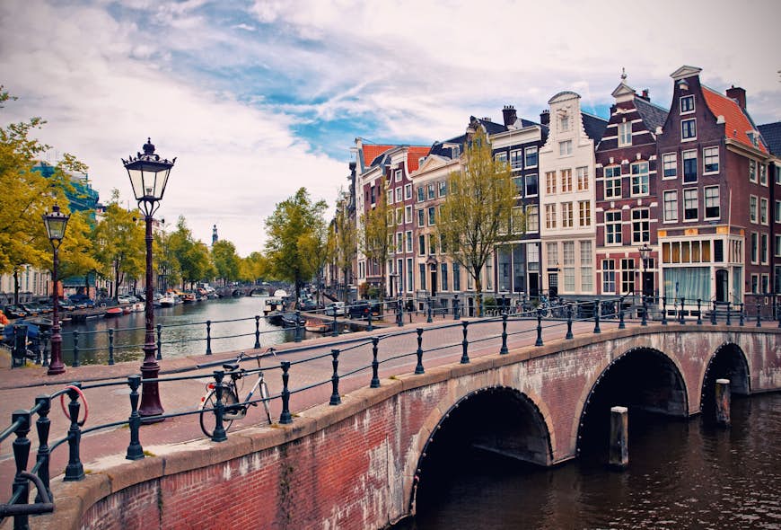 Beautiful view of Amsterdam canals with bridge and typical dutch houses.