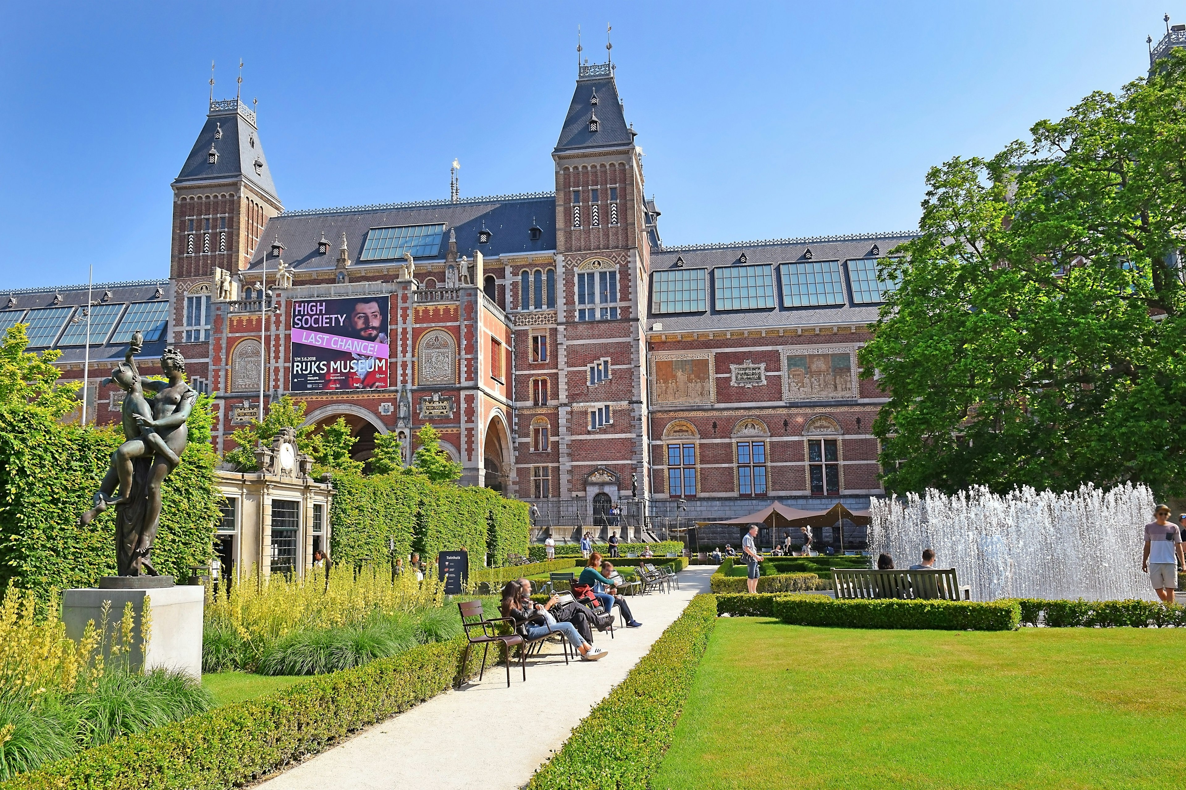 Visitors around the fountain at the Rijksmuseum garden on a sunny day.