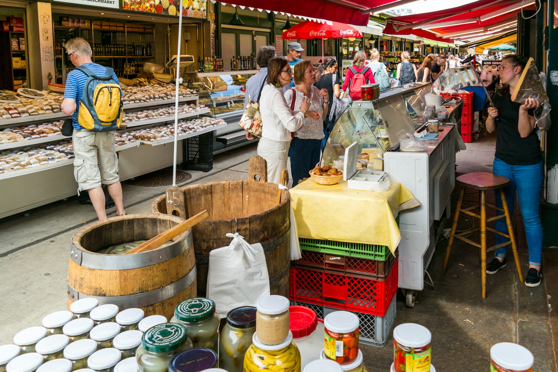 People buying food at market stands on Naschmarkt in Vienna