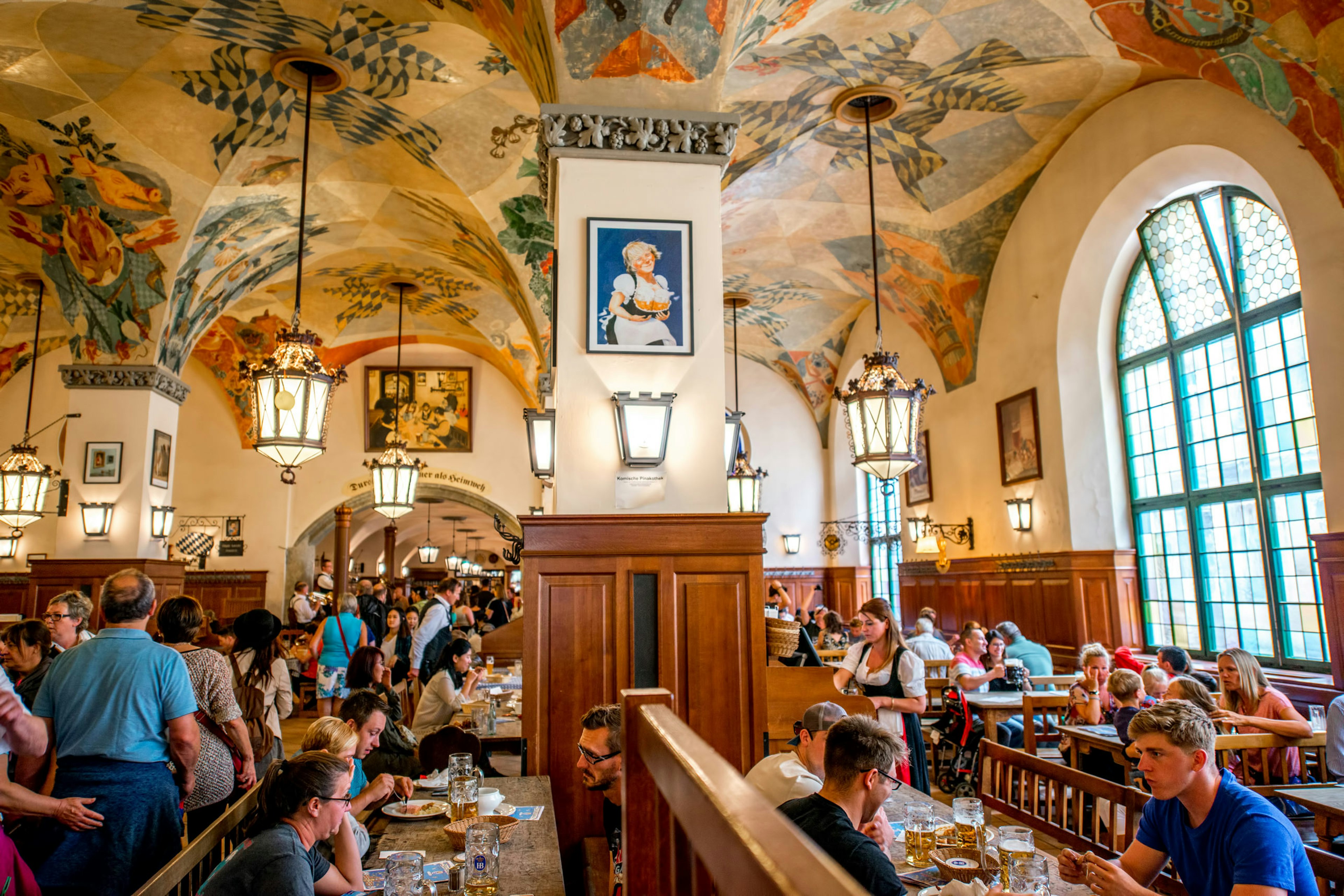 People fill tables in a large beer hall