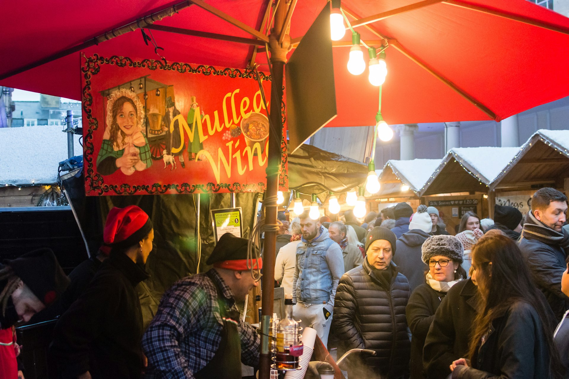 People at a mulled wine stall at the Bath Christmas Market