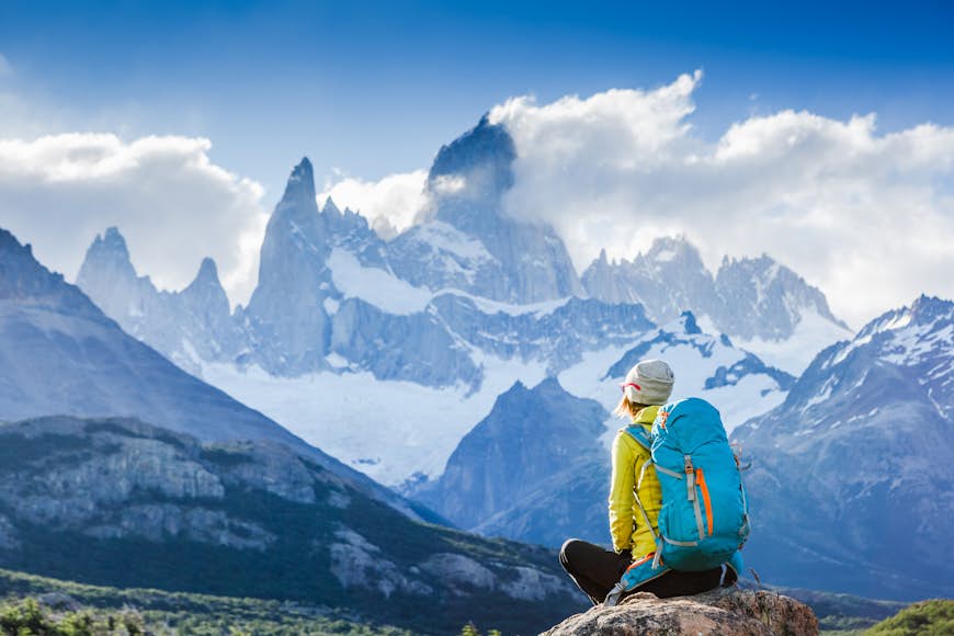 Female trekker sitting and looking towards Mt Fitz Roy, Patagonia