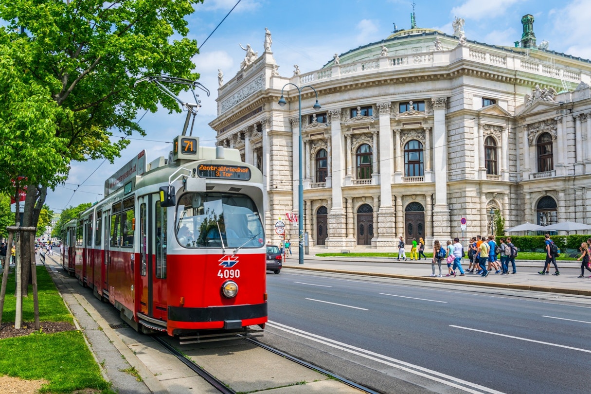 Wiener Ringstrasse with the historic Burgtheater (Imperial Court Theatre) and a traditional red electric tram.