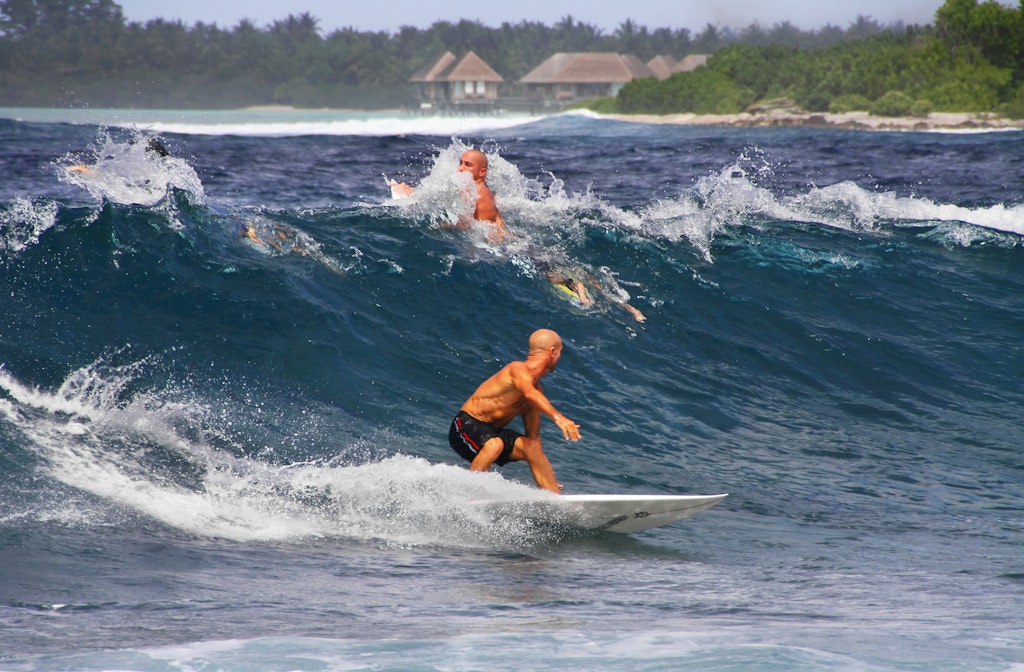 Two surfers ride breaking waves
