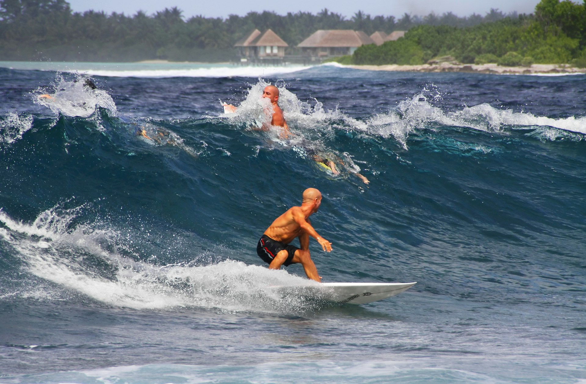 Two surfers ride breaking waves