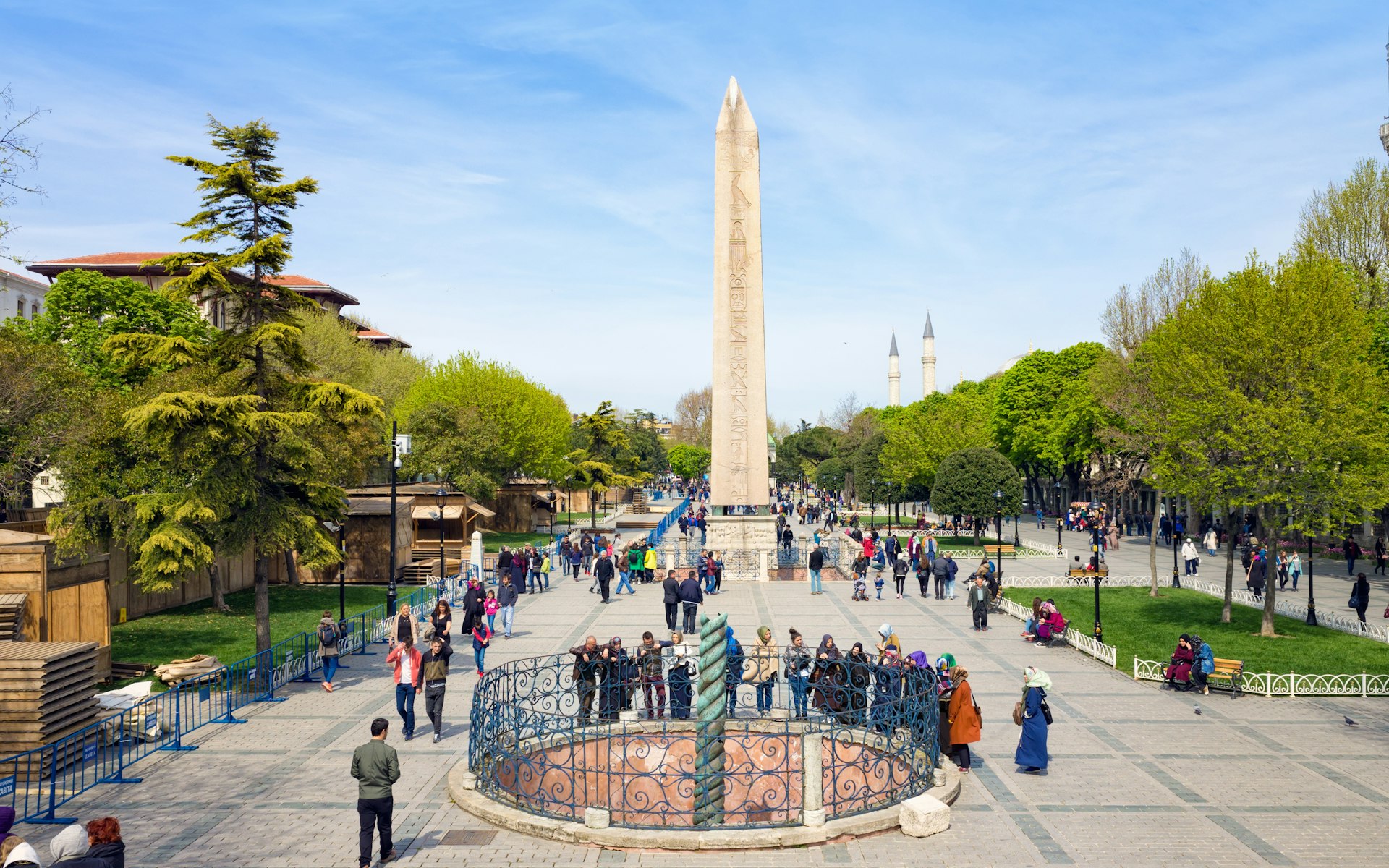 People walking near famous landmarks Obelisk of Theodosius and Serpent Column at the Hippodrome in Istanbul, Turkey