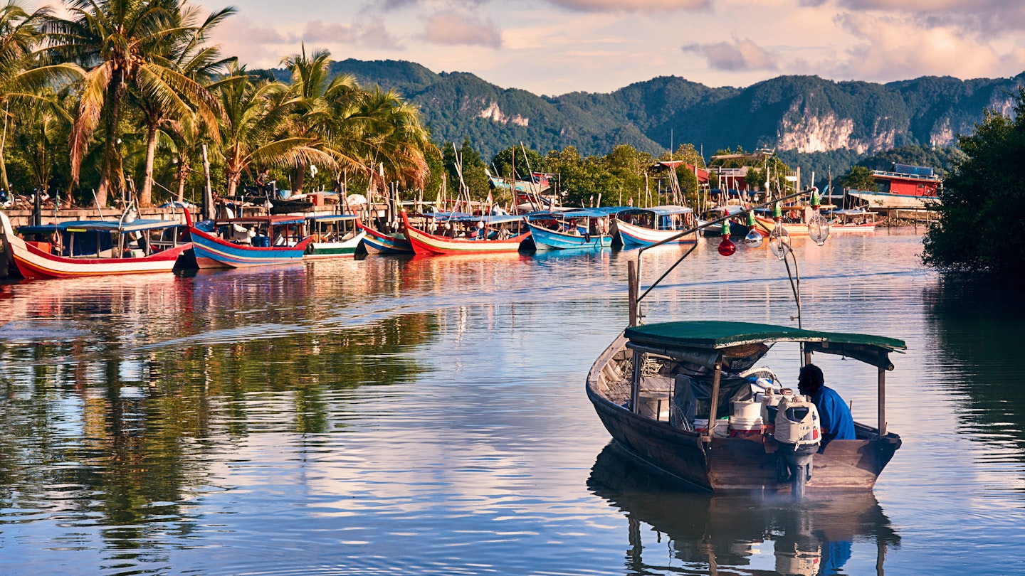 A local fisherman in a motorboat at a fishing village on Langkawi Island.