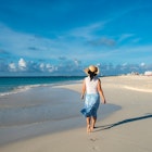 A woman walking barefoot on an Aruba beach