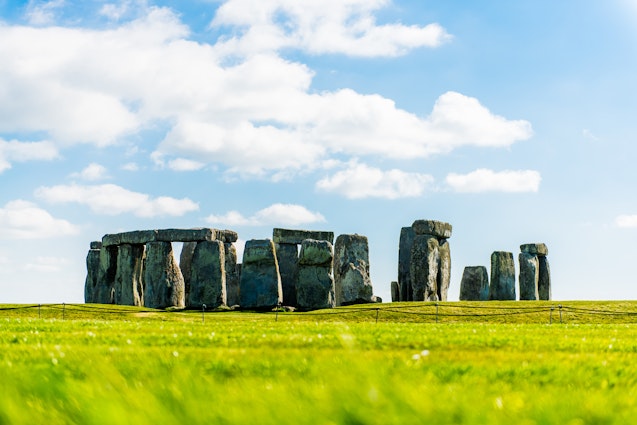 Wide view of stones at Stonehenge. Stonehenge is a prehistoric monument in Wiltshire, England and consists of a ring of standing stones. Beautiful Stonehenge wish blue sky.