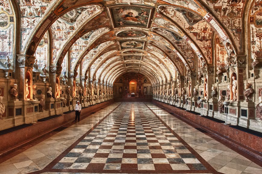 Carreaux de sol en damier, sculptures et fresques exquises tapissent les murs d'un couloir à Münchner Residenz