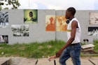 A pedestrian walked by photographs pasted on a wall for the Lagos Photo Festival, years before the Covid-19 pandemic halted all art events and closed museums.