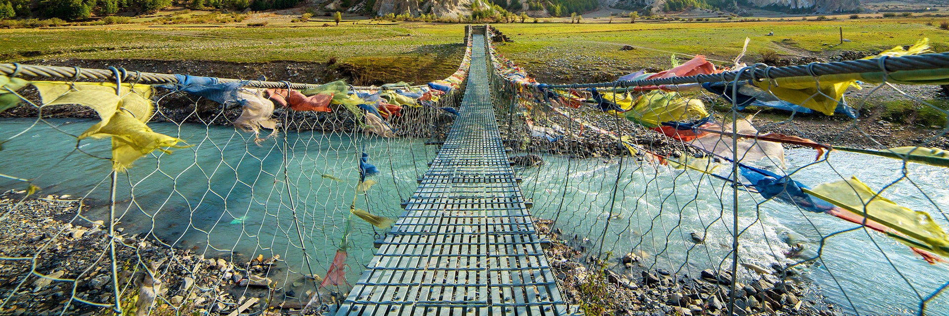 Suspension bridge with buddhist prayer flags on the Annapurna circuit trek in Nepal.