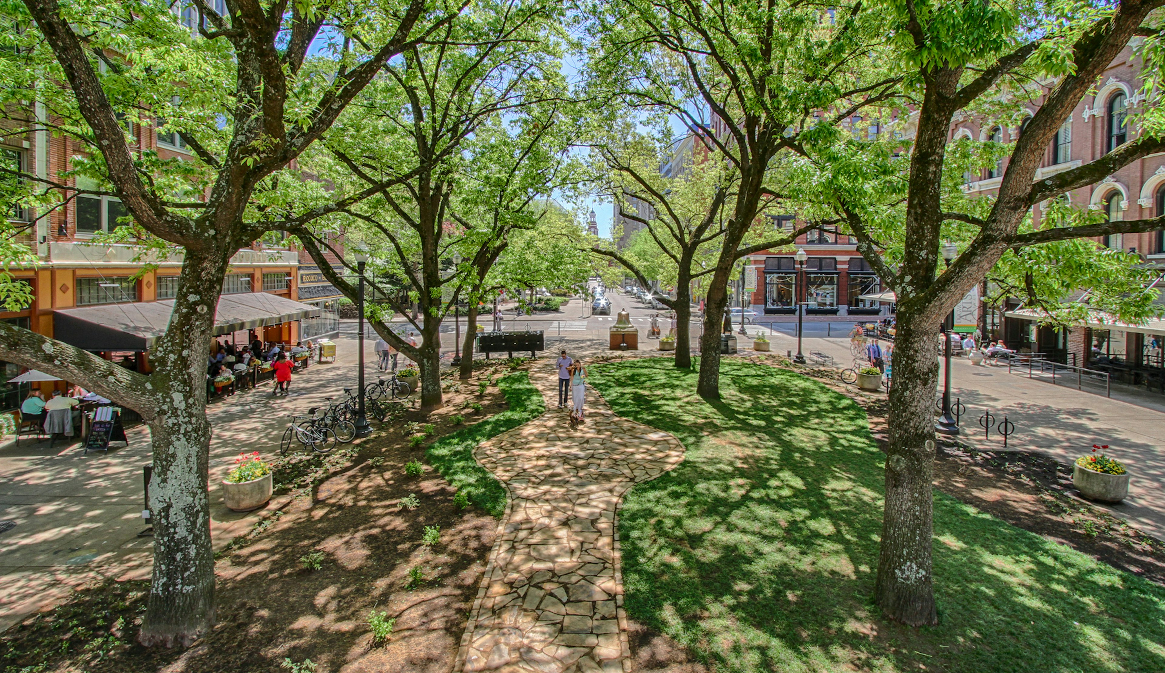 A leafy square in small town covered by trees