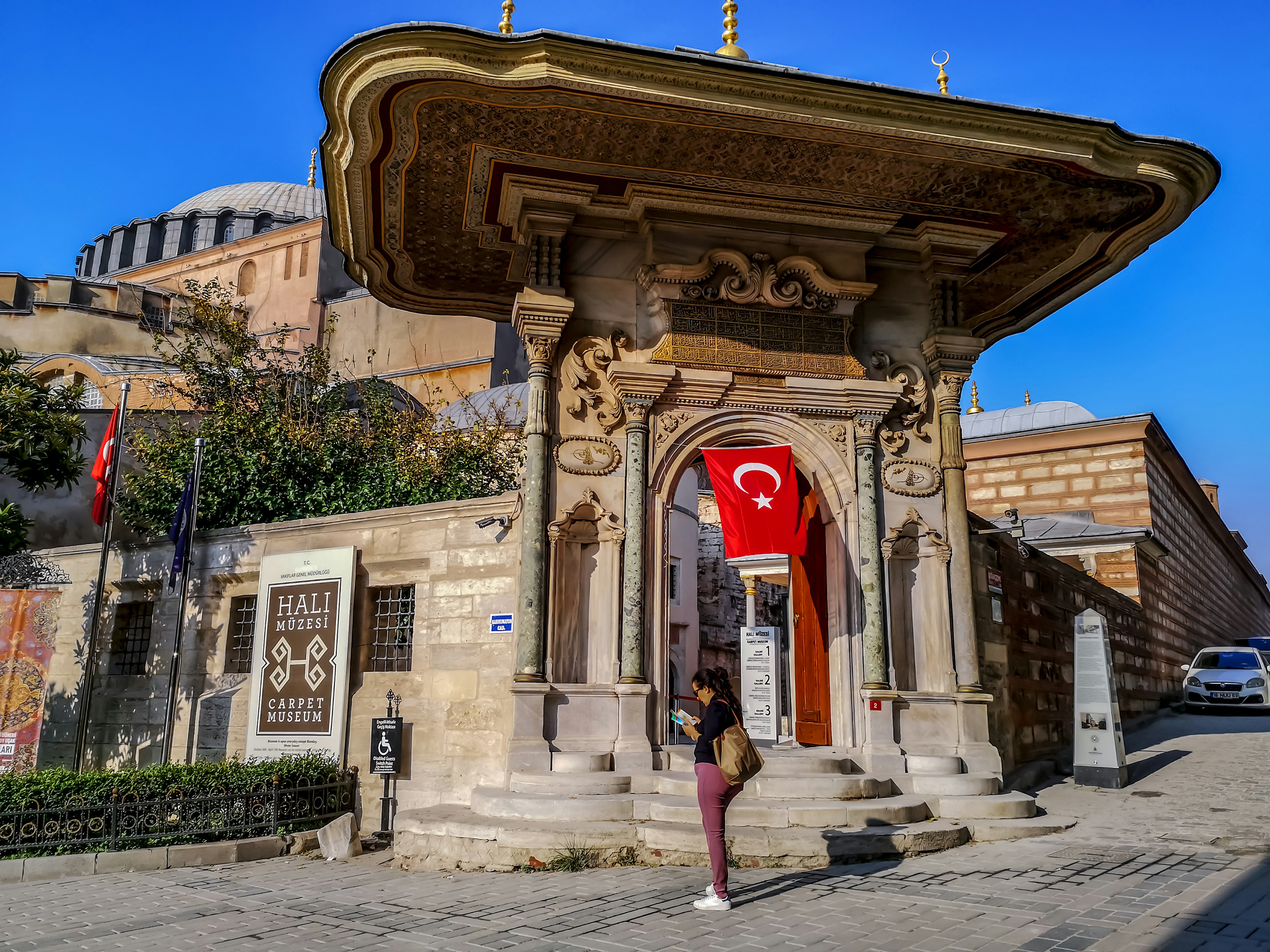 Istanbul, Turkey - October 29, 2019: An adult woman tourist with a guidebook in her hands at the entrance to the Carpet Museum in Istanbul. Turkish landmark in the old town