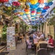 Tourists and locals having lunch in a restaurant with colorful umbrellas in top of it in the Turkish side of Nicosia in Cyprus.
