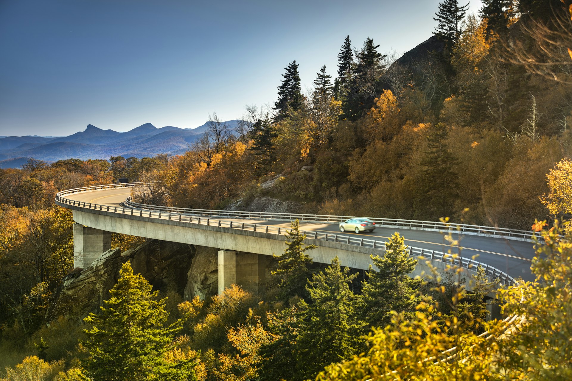 Cars travel on the Linn Cove Viaduct along the Blue Ridge Parkway in fall, North Carolina