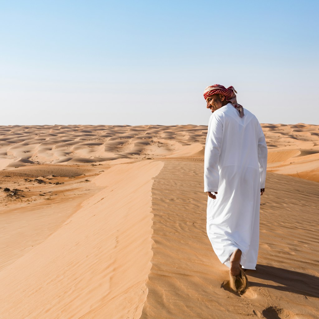 Bedouin walking in the desert, Wahiba Sands, Oman