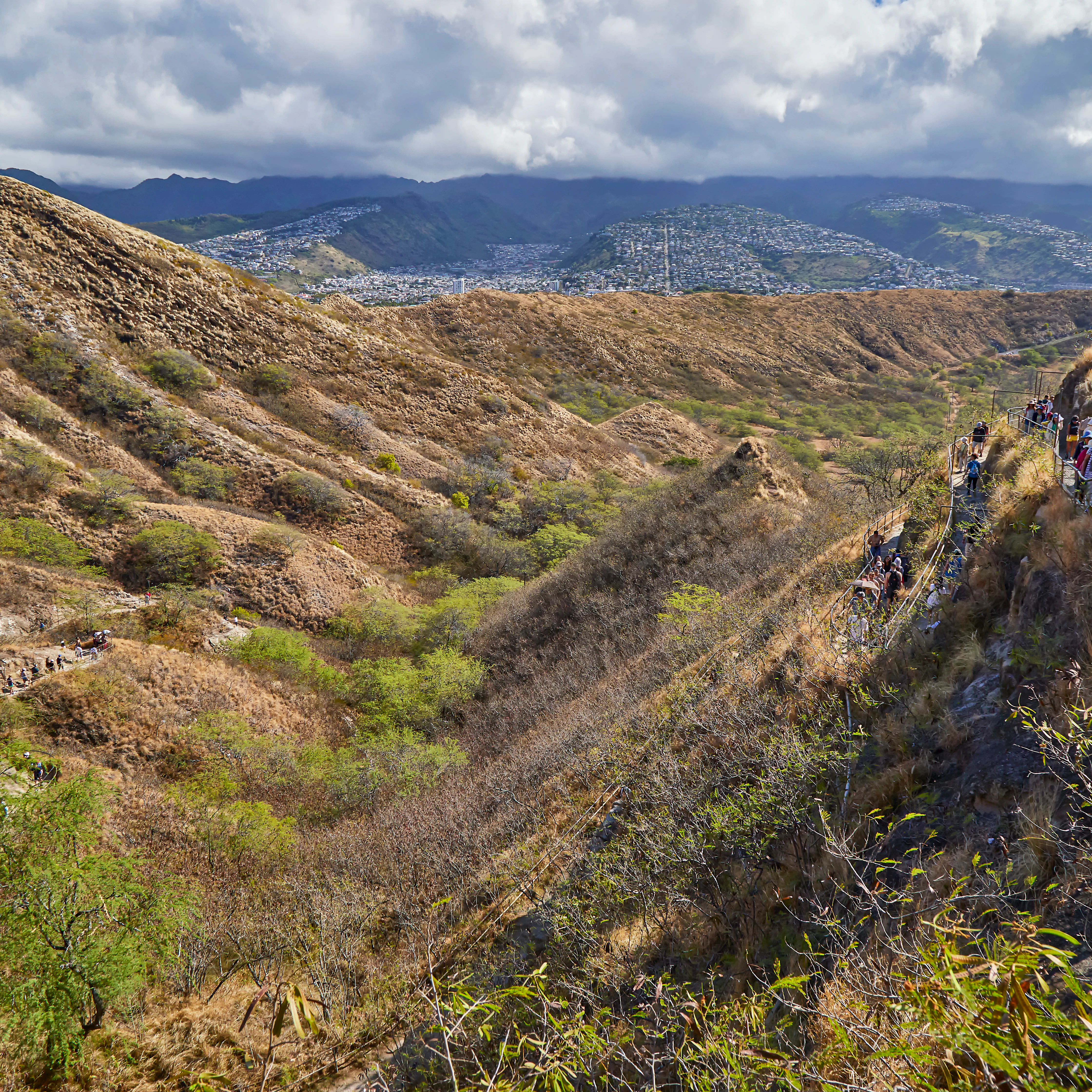People walking along the walking path up and down to the top lookout of Diamond Head State Monument.