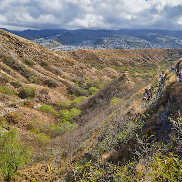 People walking along the walking path up and down to the top lookout of Diamond Head State Monument.