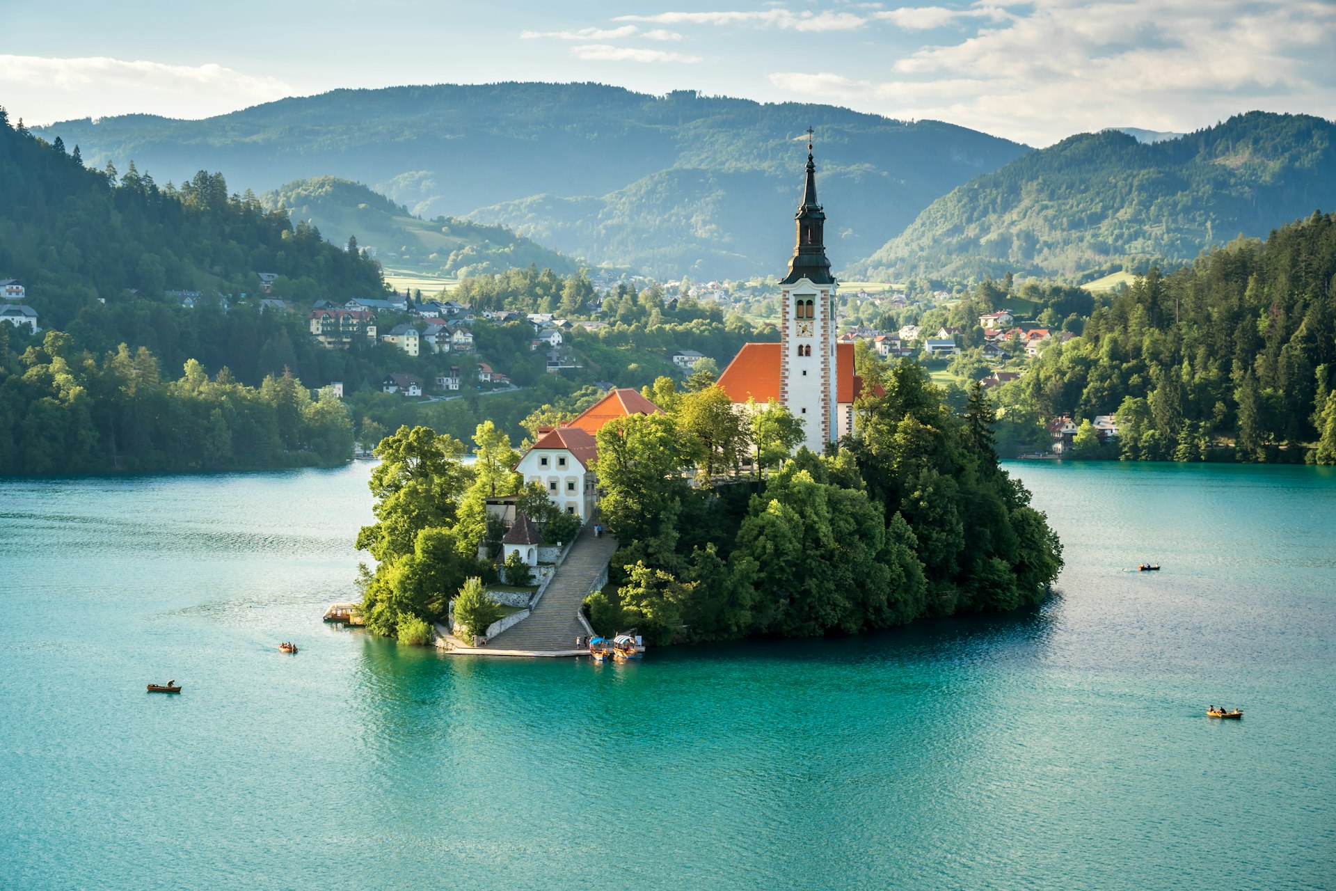 An island with a church in the middle of the turquoise waters of Bohinj Lake 