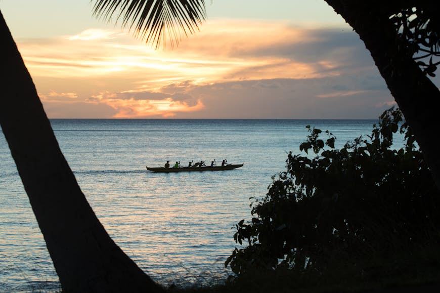 Hawaiian outrigger canoes and palm trees on the beach at sunset, Kihei, Maui, Hawaii, USA