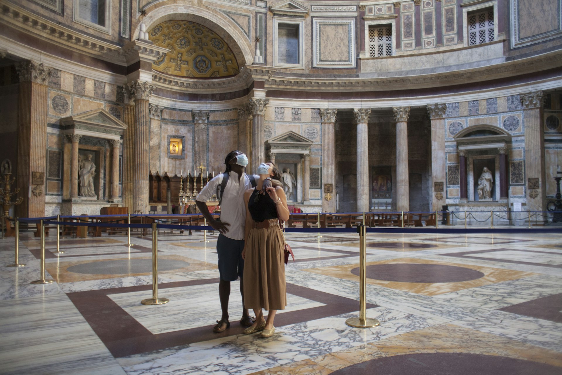 Couple enjoying the empty Pantheon in Rome, wearing protective face masks during COVID-19 pandemic