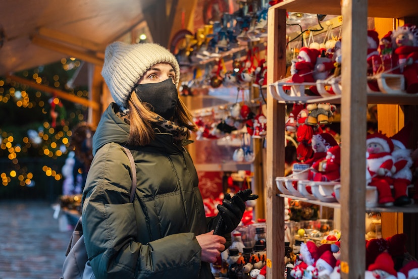 Woman in face mask on Christmas shopping on market in Tallinn, Estonia