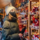 Woman in face mask on Christmas shopping on market in Tallinn, Estonia
