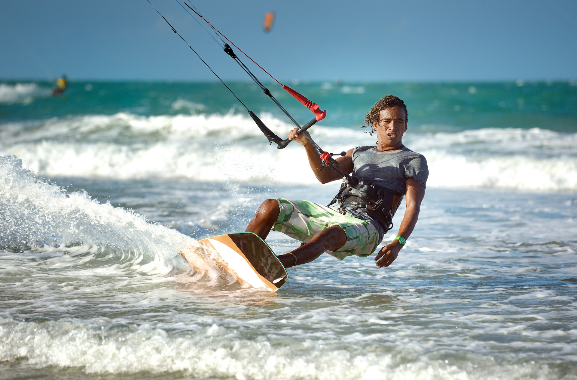 A kitesurfer glides across the shallow waters 