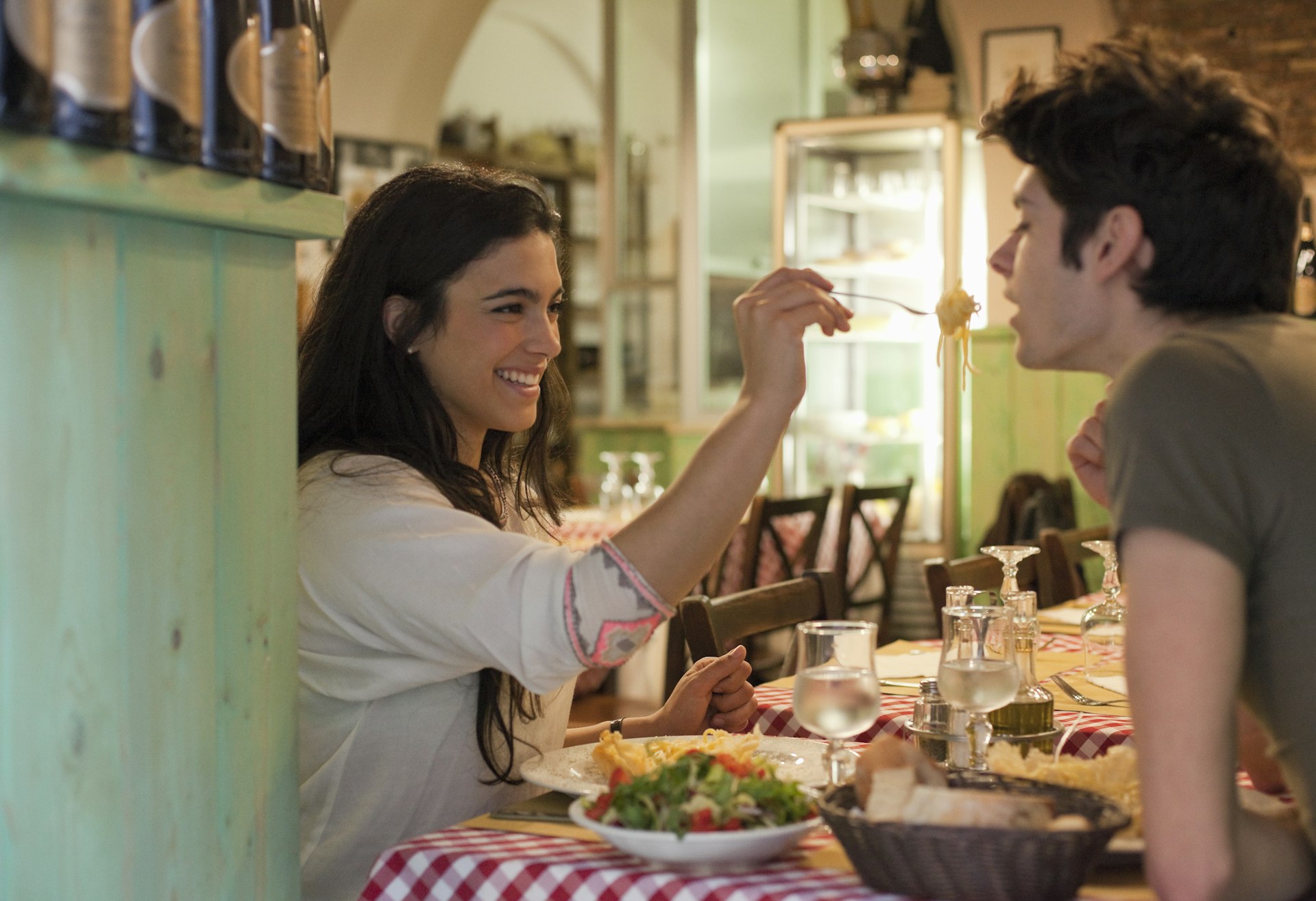Happy young couple eating together in restaurant in Rome, Italy. 