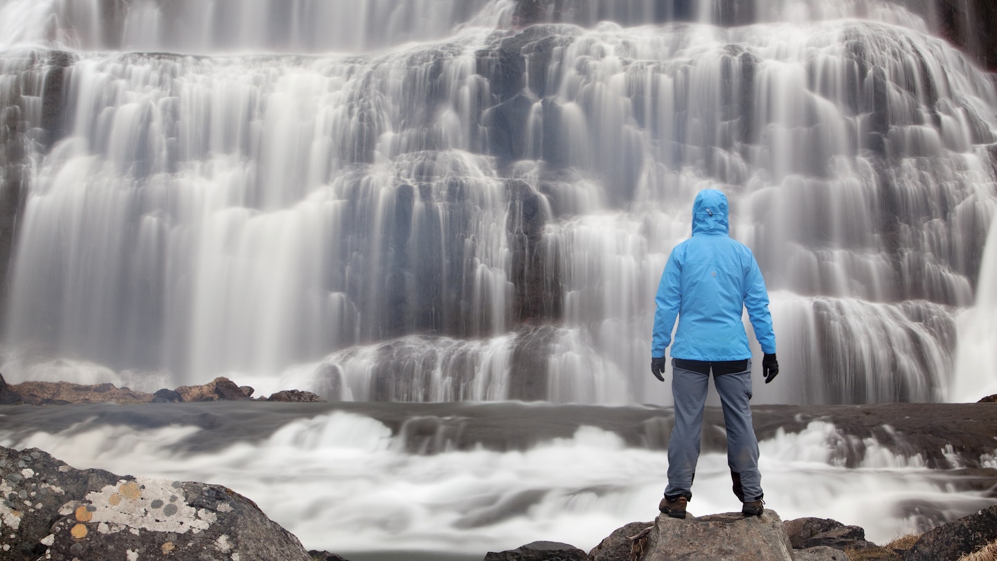 Hiker in front of the Dynjandi waterfall, Westfjords