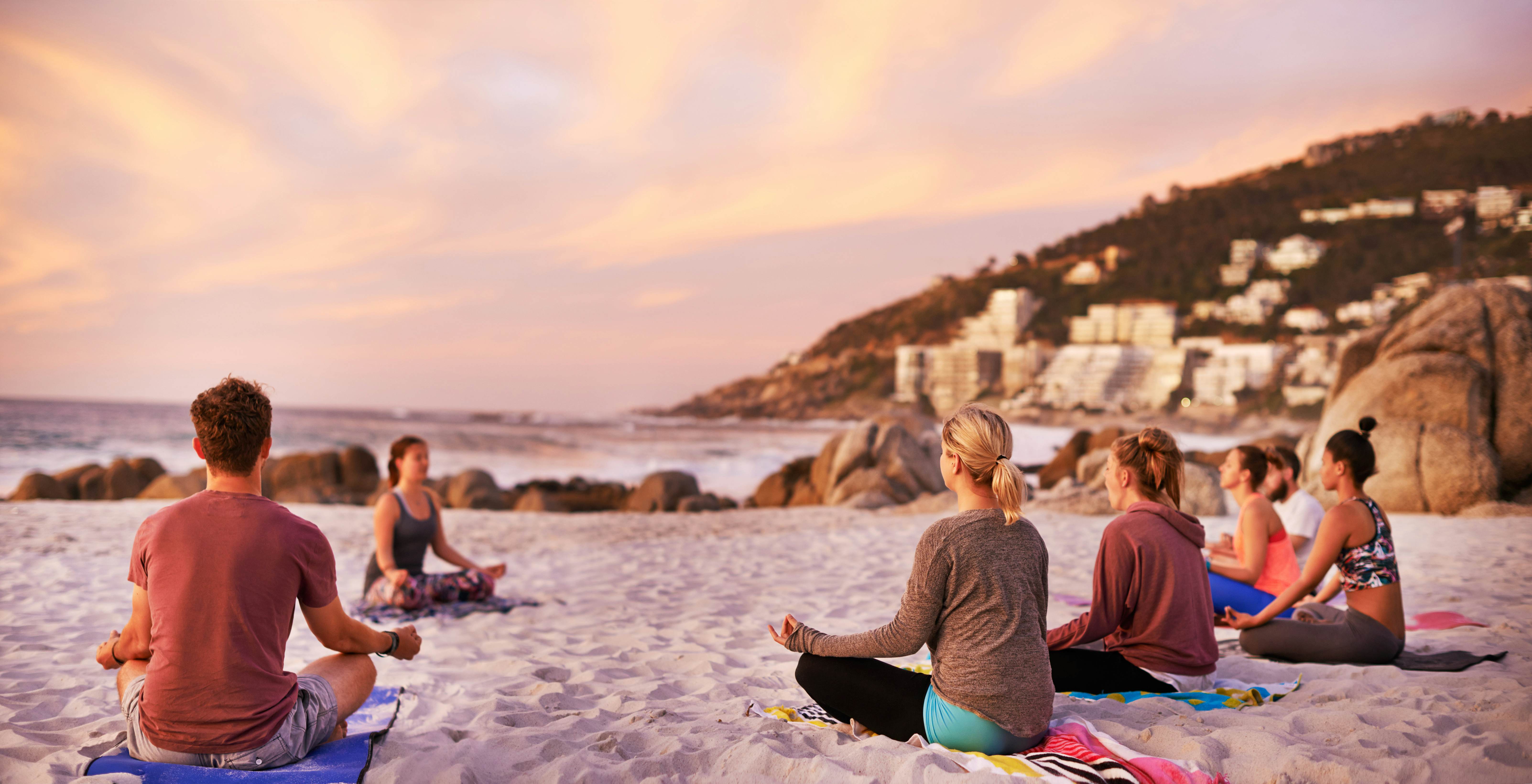 people having a yoga session on the beach