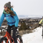 A couple riding fat tire bikes in the snow near Bozeman