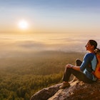 A female hiker watches sunrise from a mountain outside Boulder, CO