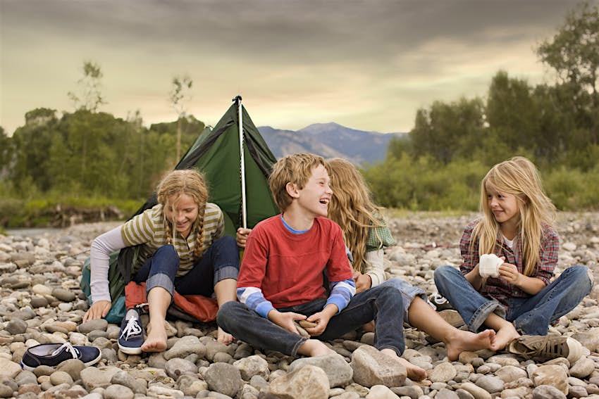 Brother and sisters camping at a free campsite near Bozeman/Gallatin Valley, Montana Brother and sisters playing in small tent on a rocky creek bank