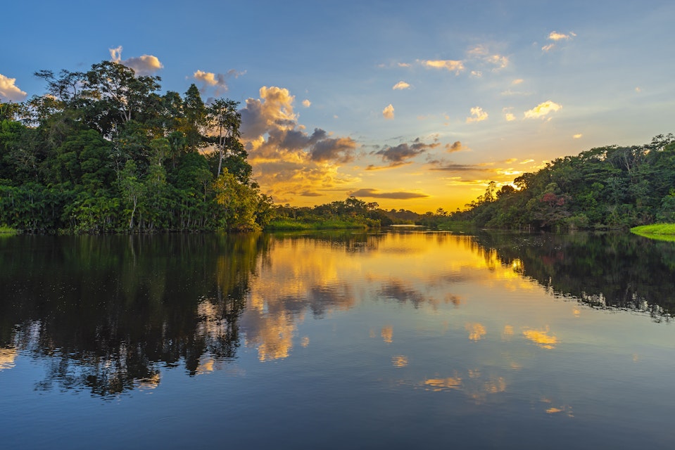 Reflection of a sunset over a lagoon in the Amazon Rainforest Basin in Ecuador.