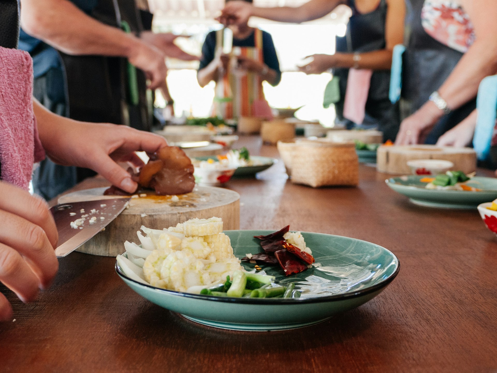 A group of tourists prepare ingredients during a Thai cooking lesson in Chiang Mai
