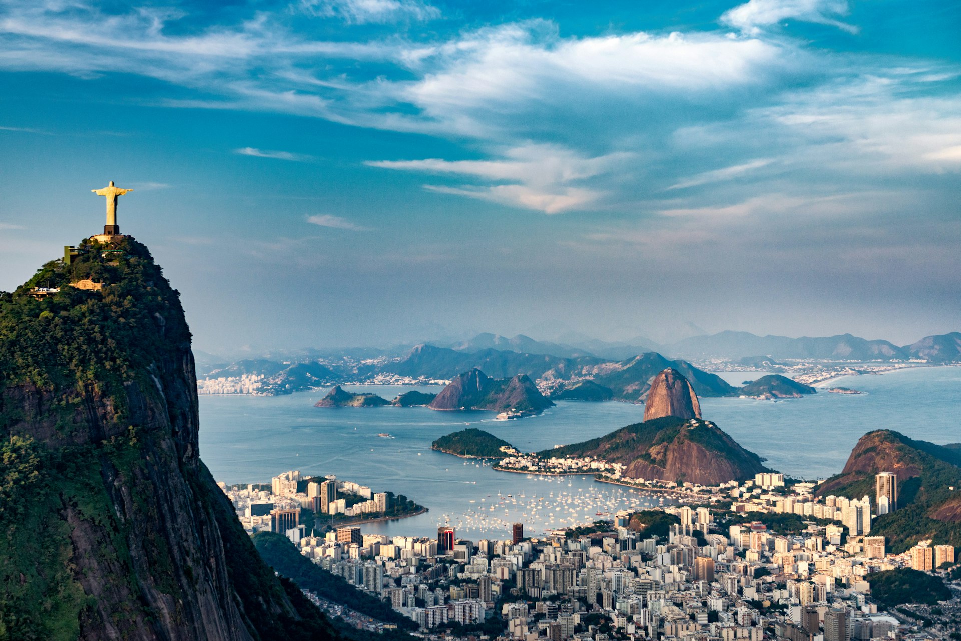An aerial shot of Rio de Janeiro showing Christ the Redeemer on Corcovado Mountain, Sugarloaf Mountain and Guanabara Bay