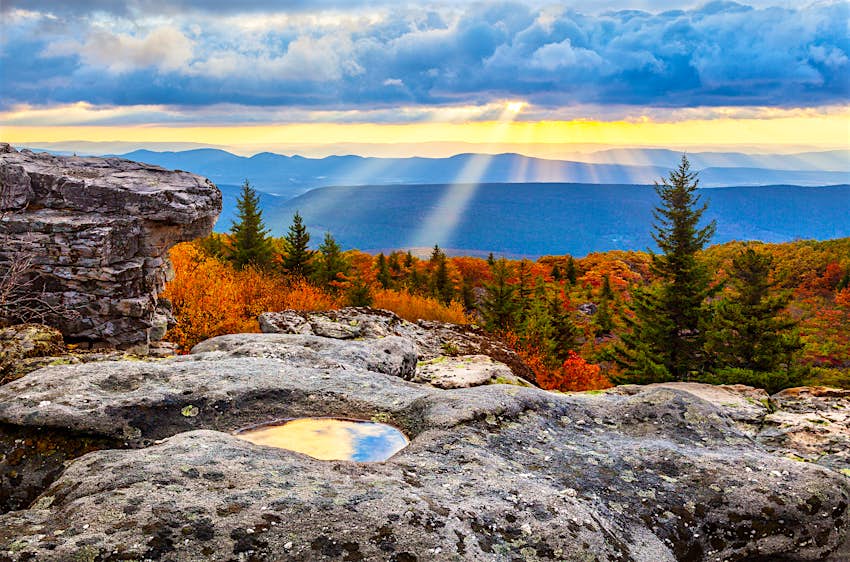 Sunrise from Dolly Sods Wilderness Area in West Virginia, with autumn foliage and sunbeans coming through dark clouds 