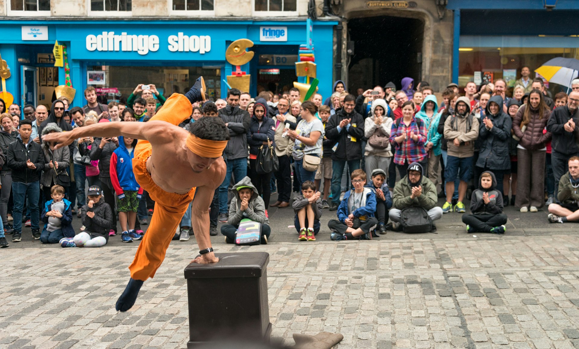 A street performer entertaining spectators on the Royal Mile during the Edinburgh Festival Fringe