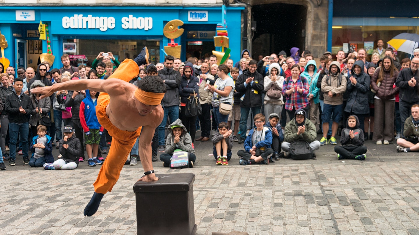 A street performer entertaining spectators on the Royal Mile during the Edinburgh Festival Fringe.