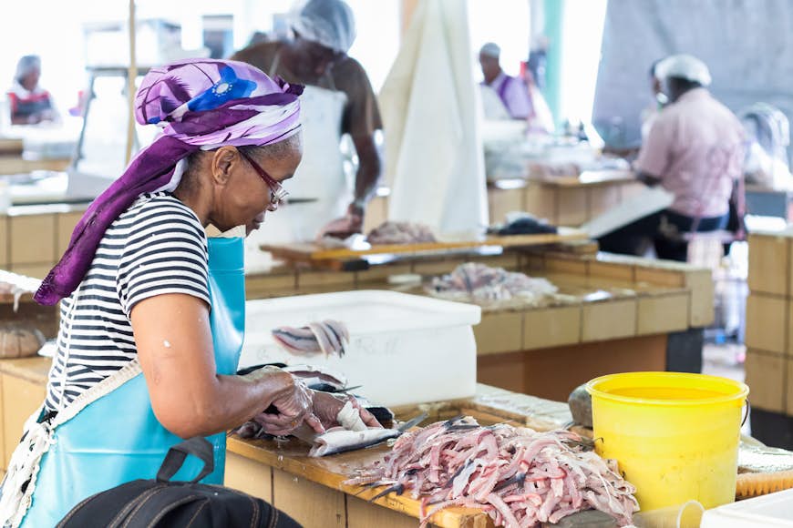 Preparing fresh flying fish for sale at the Bridgetown Fish Market.